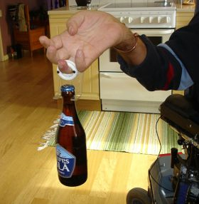 کاربر با انگشت خود که داخل حلقه کرده بطری را نگه می دارد