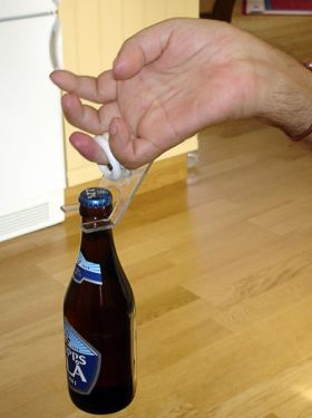کاربر انگشت خود داخل حلقه کرده و بطری را بلند می کند ( از نمای نزدیک )